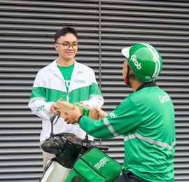 a person in green and white uniform handing a box to another person
