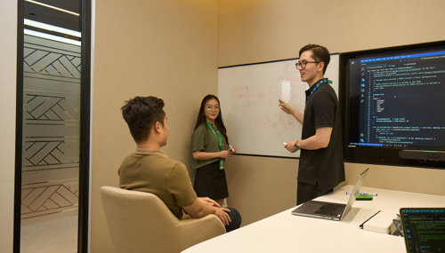 a person standing next to a whiteboard with a person pointing at it