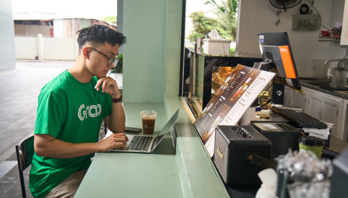 a person sitting at a counter using a laptop