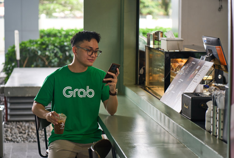 a person sitting at a table looking at a phone
