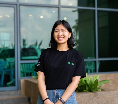a woman smiling in front of a building