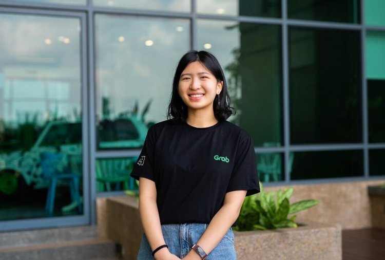 a woman smiling in front of a building