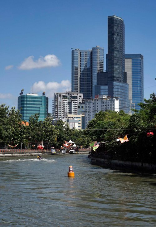 a body of water with trees and buildings in the background