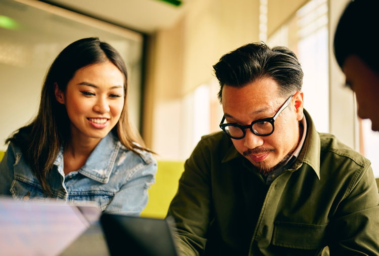 a man and woman looking at a laptop