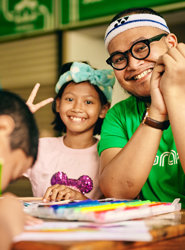 a man and a girl sitting at a table with coloring books