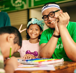 a man and a girl sitting at a table with coloring books