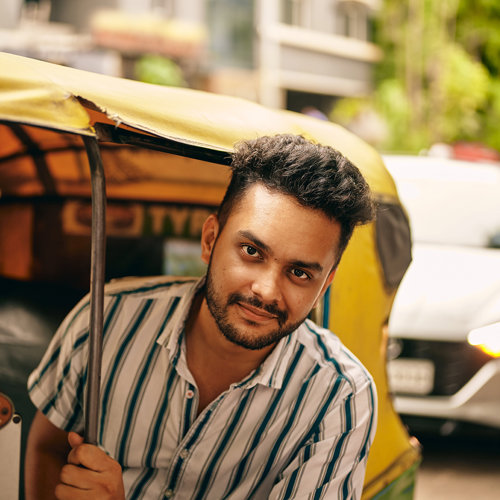 a man sitting in a yellow and green vehicle