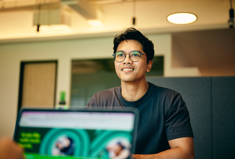 a man sitting at a desk with a laptop