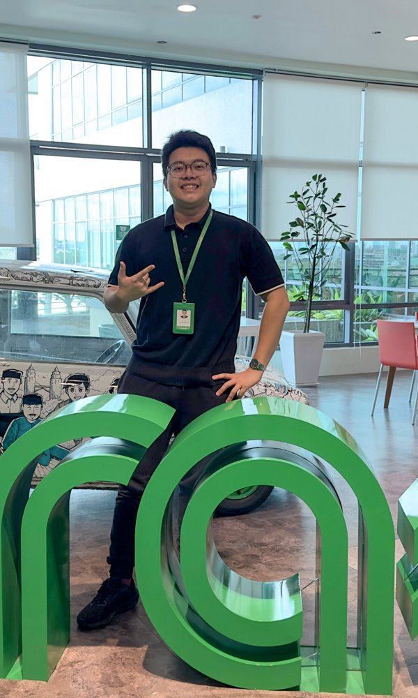 a person standing in front of green letters