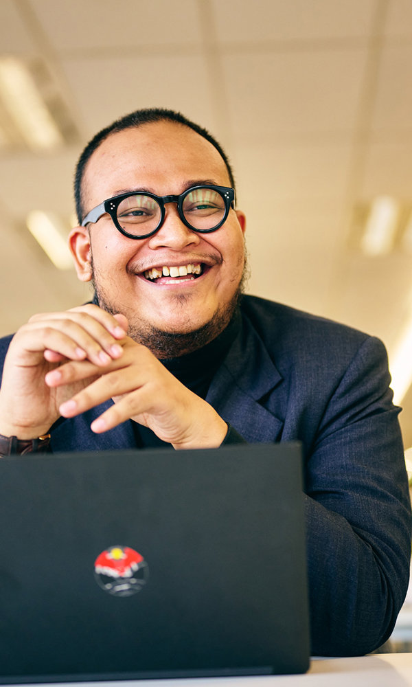a man smiling at a laptop