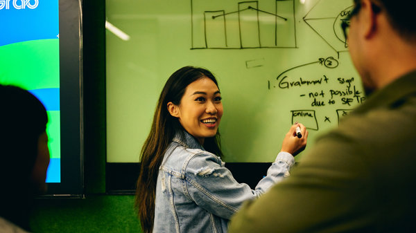 a woman writing on a whiteboard