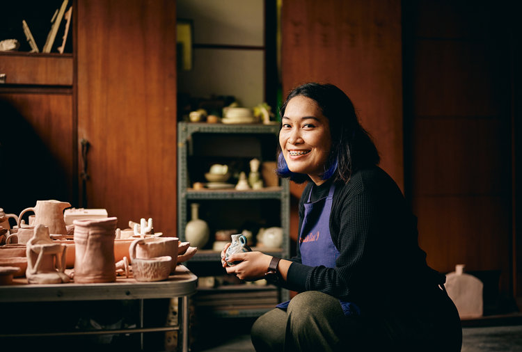 a woman smiling while holding a small object