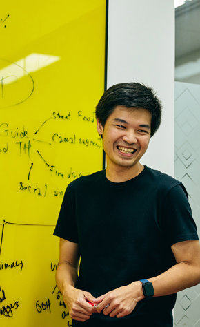 a man standing in front of a yellow board