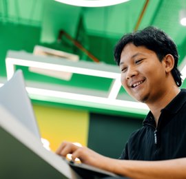 a person smiling at a laptop