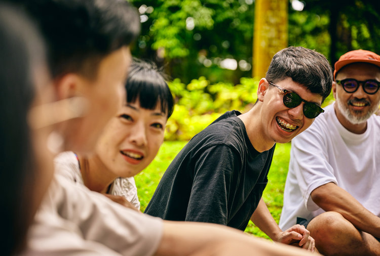 a group of people sitting on grass