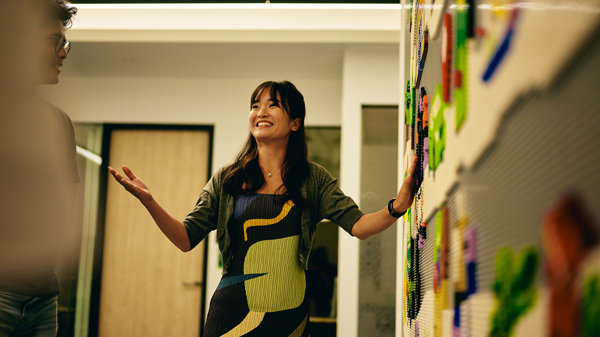 a woman standing in front of a wall with magnets