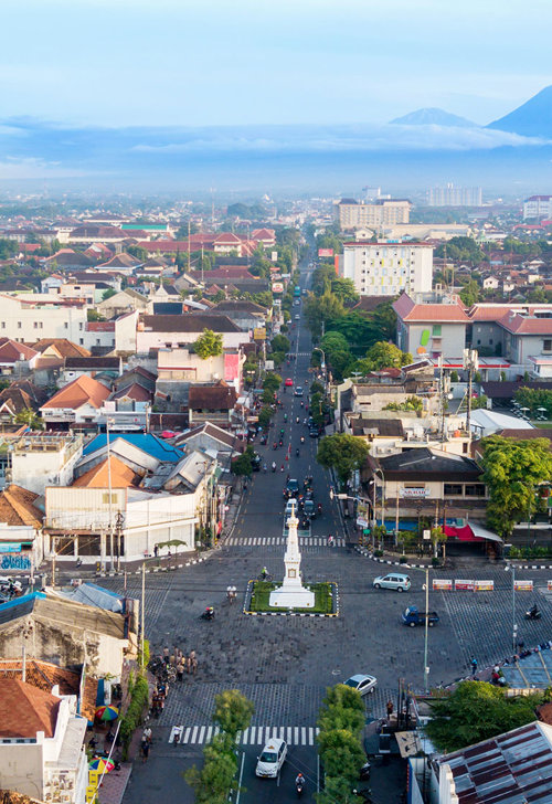 a city with many buildings and a statue in the middle
