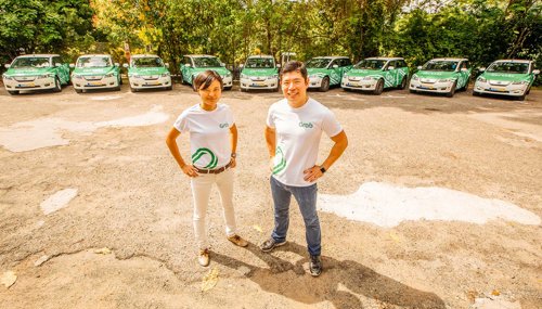 a man and woman standing in front of parked cars
