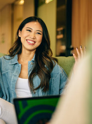 a woman sitting on a couch with her hands up