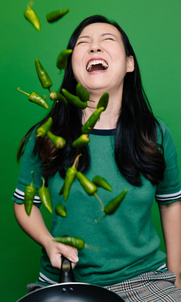 a woman throwing green peppers
