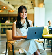 a woman sitting in a chair with a laptop