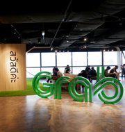 a group of people sitting in a room with large green letters