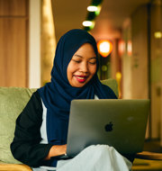 a person sitting on a chair with a laptop