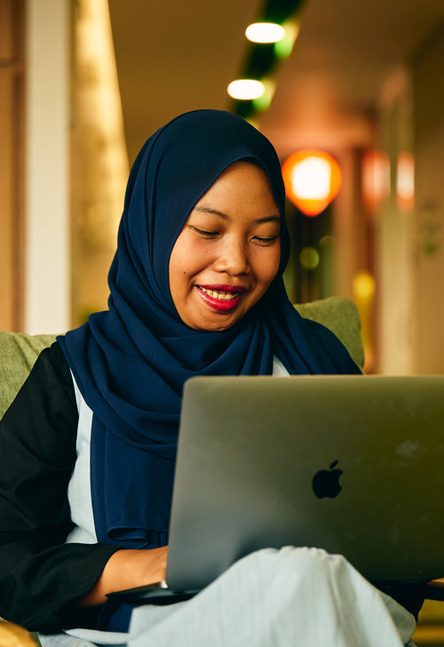 a person sitting on a chair with a laptop