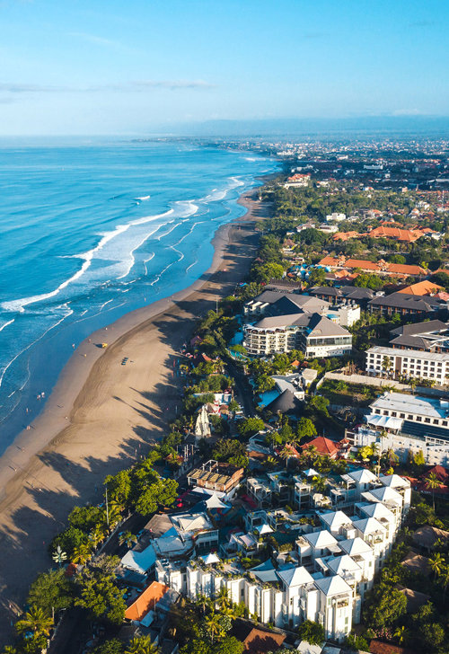 a beach with buildings and trees