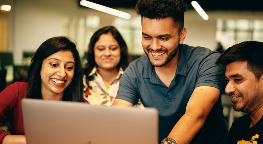a group of people looking at a laptop