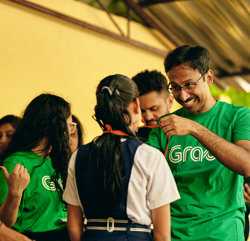 a man in green shirt smiling at a group of people