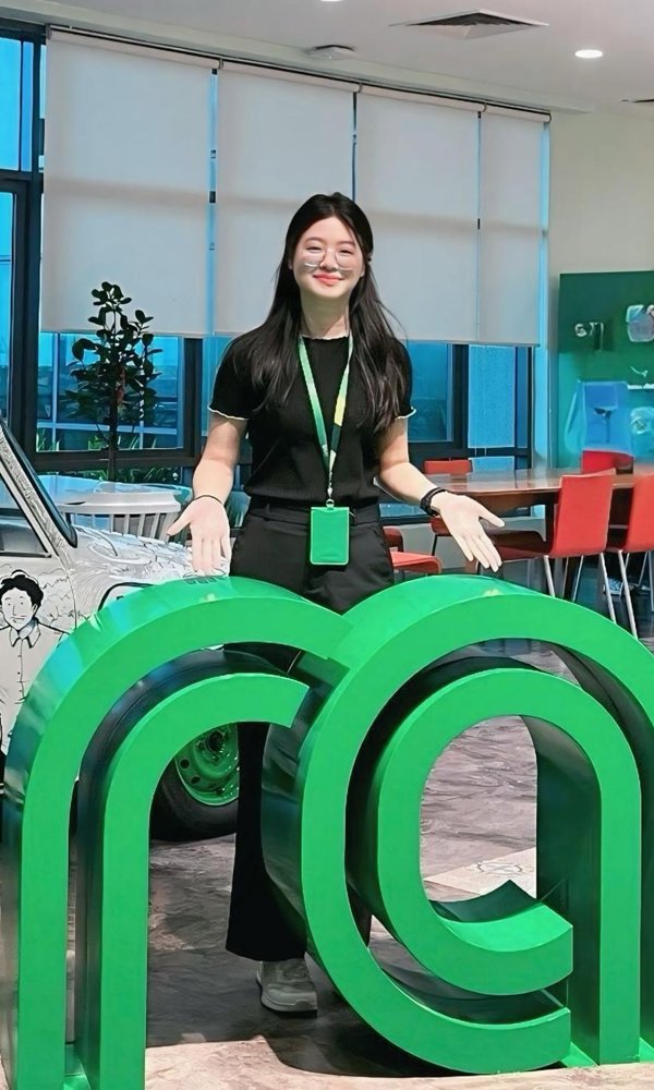 a person standing in front of large green letters