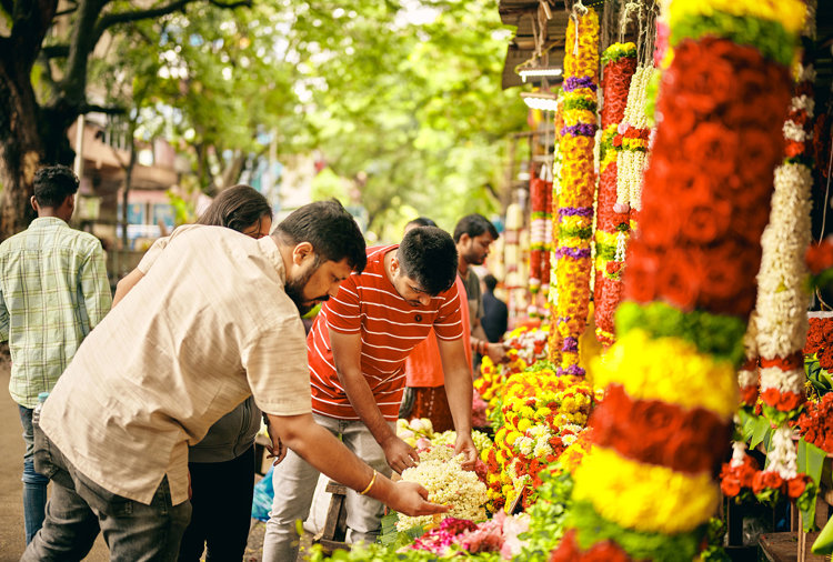 a group of people standing next to a flower shop