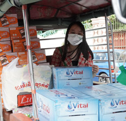 a woman wearing a face mask and sitting in a vehicle with boxes