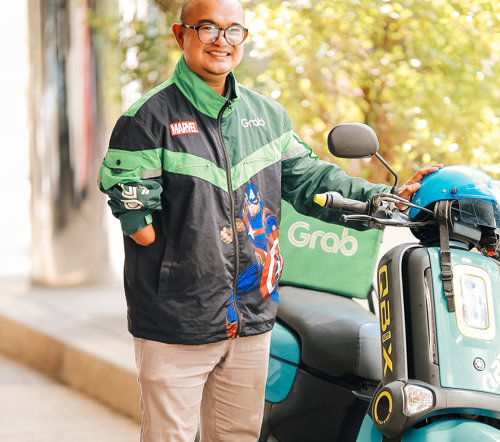 a man standing next to a scooter