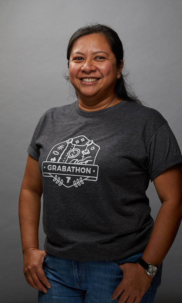 a woman smiling with her hands in her pockets