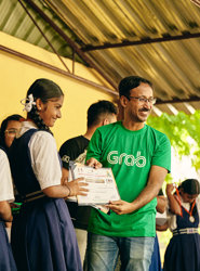 a man holding a paper with a group of girls in the background