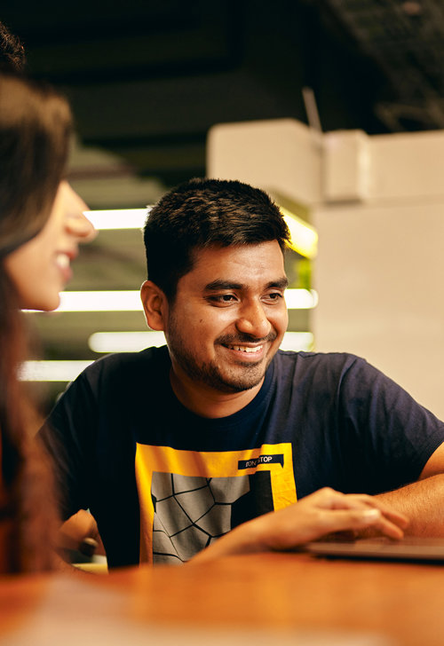 a man and woman sitting at a table looking at each other
