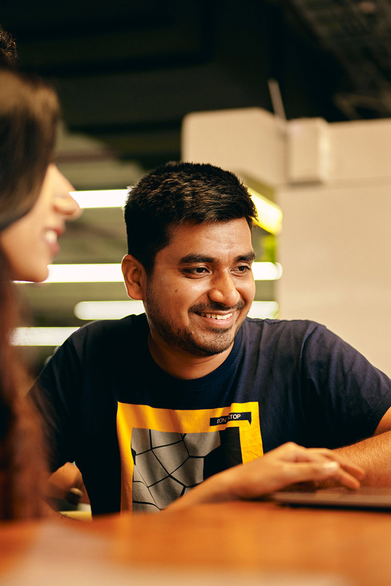 a man and woman sitting at a table looking at each other