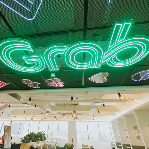 a green neon sign on a ceiling